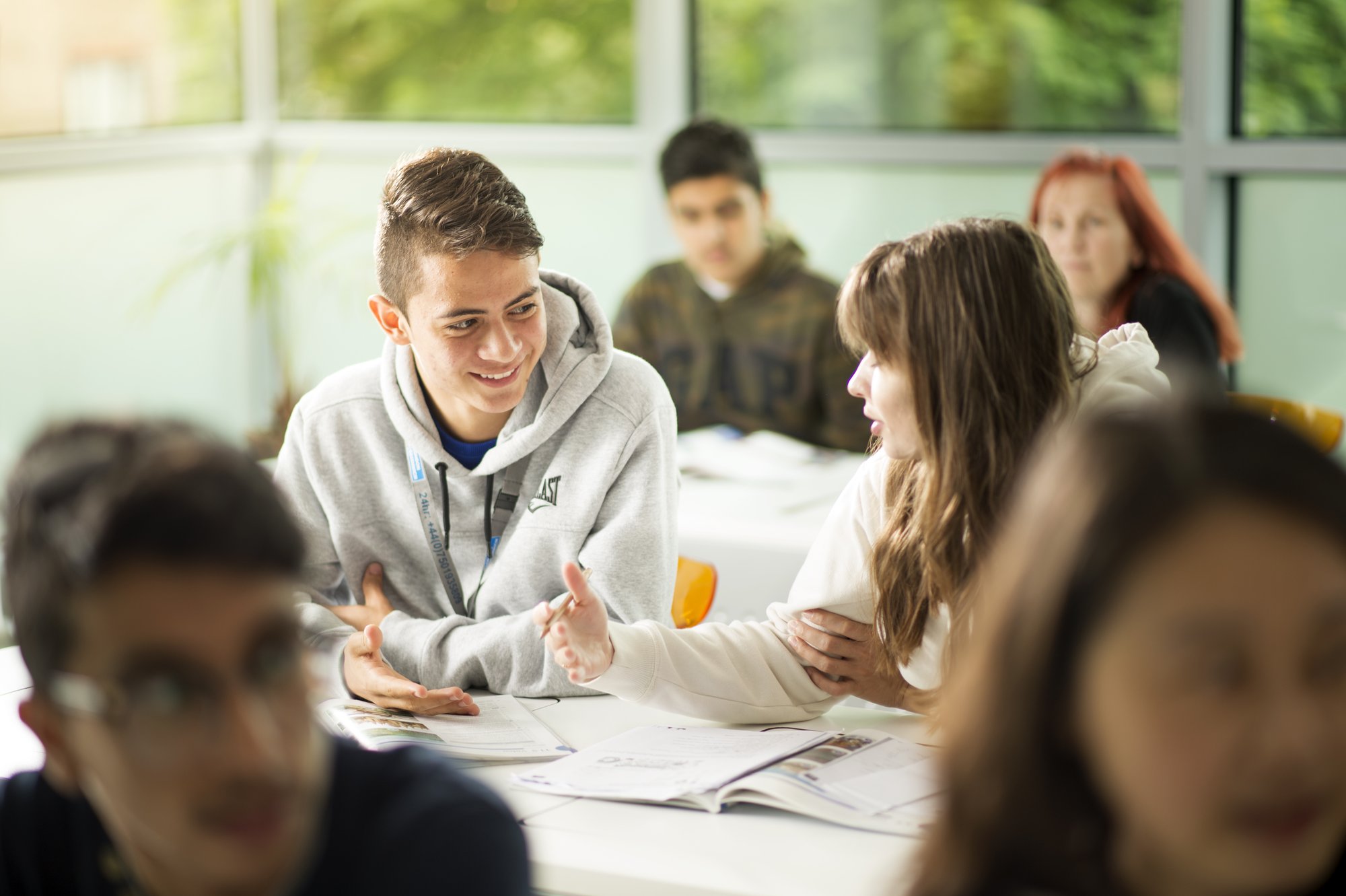 Two students at a desk chatting